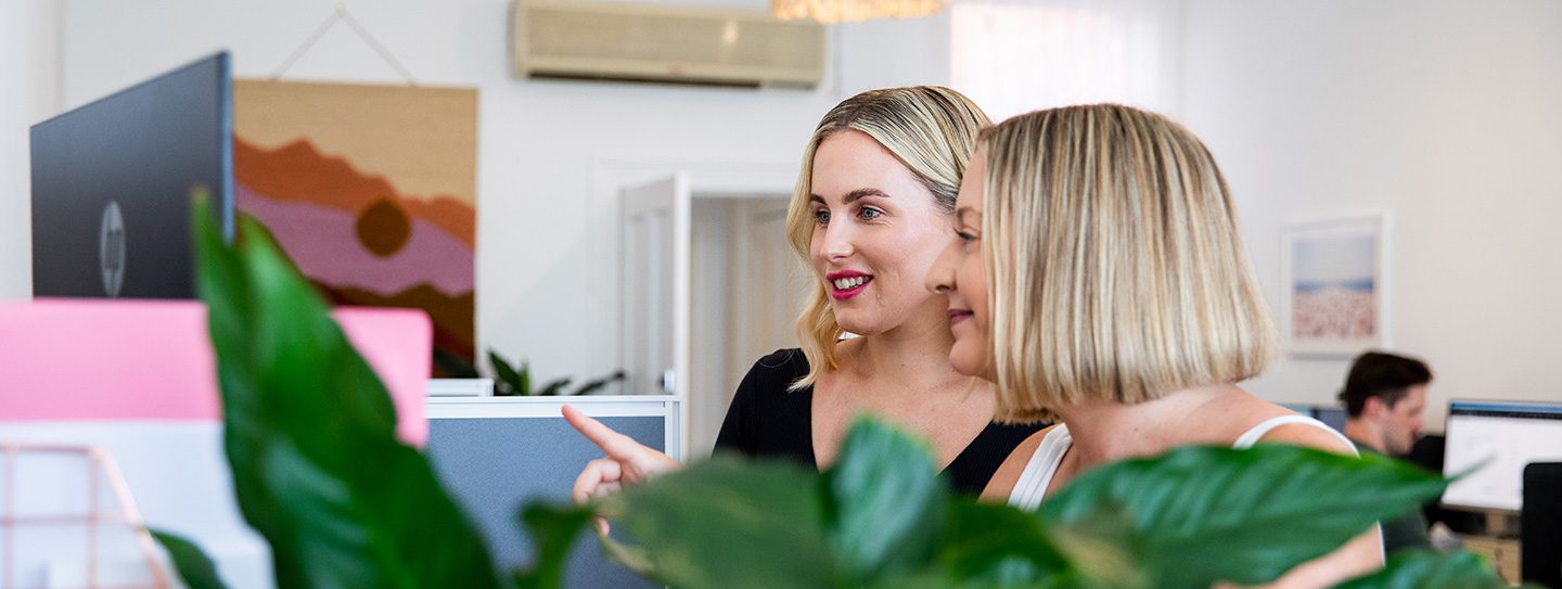 Image of Amy and Mia working in the Equality Media + Marketing office